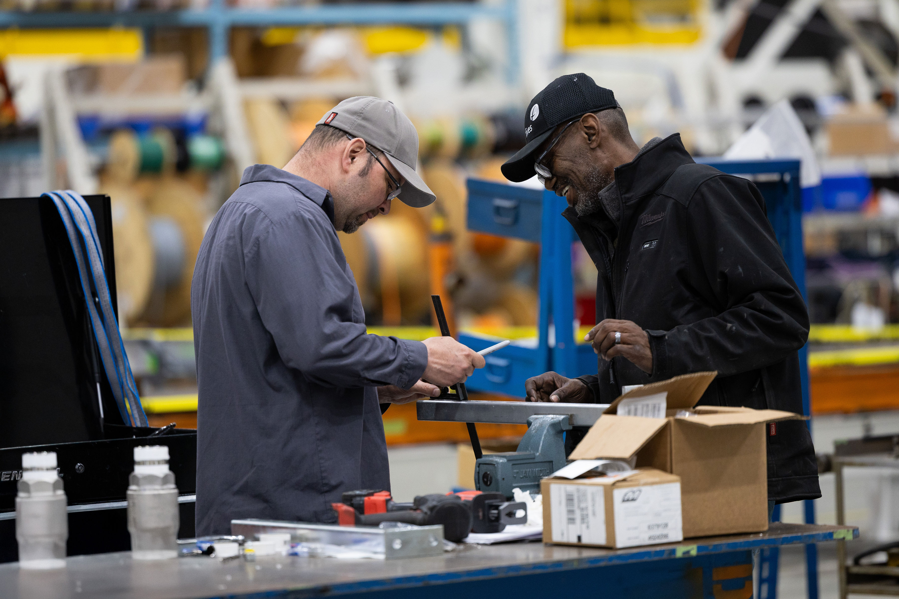 Industrial technicians inspecting and measuring equipment in a manufacturing facility