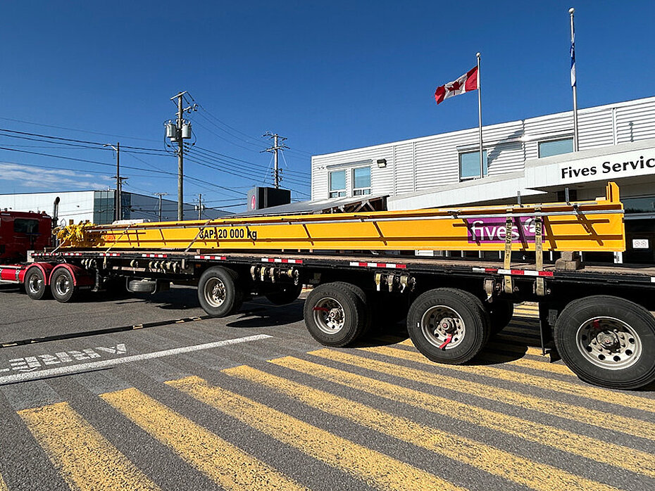 Poutres de pont roulant jaunes sur des remorques de transport avant leur livraison ou leur installation.